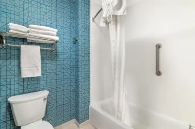 a bathroom with a white toilet and a blue tiled wall at Homewood Suites By Hilton Schenectady in Schenectady