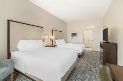 a hotel room with two beds and a flat screen tv at Homewood Suites By Hilton Schenectady in Schenectady