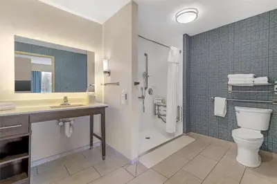 a bathroom with a shower and a toilet and a sink at Homewood Suites By Hilton Schenectady in Schenectady