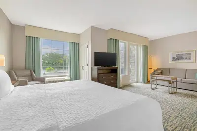 a hotel room with a bed and a flat screen tv at Homewood Suites By Hilton Schenectady in Schenectady