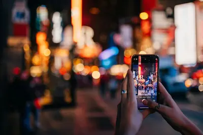 a person taking a picture on a cell phone at Renaissance New York Times Square by Marriott in New York