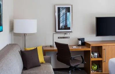 a room with a desk and a chair and a tv at Hyatt Place Long Island City in Queens