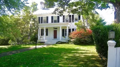 a white house with a red door on a yard at Millbrook Country House in Millbrook