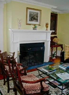 a living room with a fireplace and a table and chairs at Millbrook Country House in Millbrook