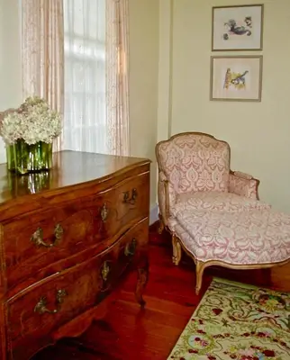 a living room with a dresser and a chair and a drawer at Millbrook Country House in Millbrook