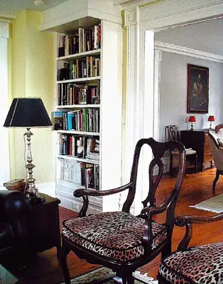a living room with a chair and a book shelf with books at Millbrook Country House in Millbrook
