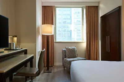 a hotel room with a bed and a desk and a window at Sheraton Brooklyn New York in Brooklyn
