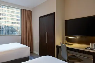 a hotel room with a bed and a desk with a television at Sheraton Brooklyn New York in Brooklyn