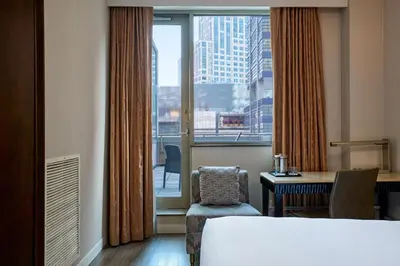 a hotel room with a bed and a desk and a window at Sheraton Brooklyn New York in Brooklyn