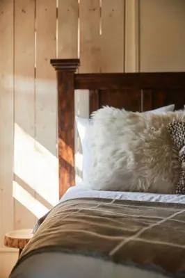 a bed with a white pillow and a wooden headboard at The Country Inn in Stone Ridge
