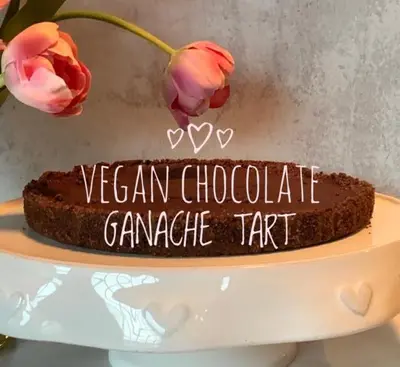 a chocolate cake sitting on a table with flowers at The Country Inn in Stone Ridge