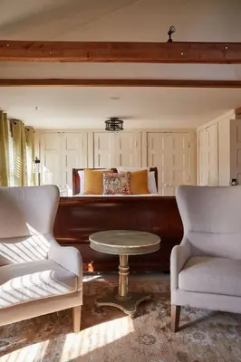 a bedroom with a bed with a table and two chairs at The Country Inn in Stone Ridge