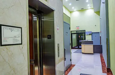a hallway with an elevator in a building at Elmhurst Hotel in Queens