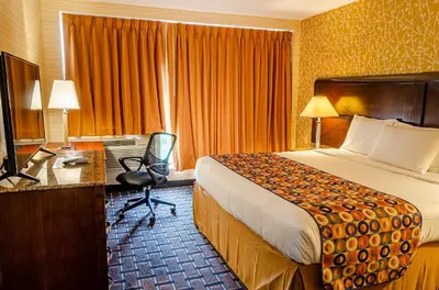 a hotel room with a bed and a desk at Elmhurst Hotel in Queens
