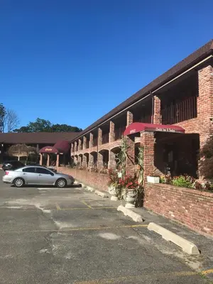 a car parked in a parking lot next to a brick building at Chalet Inn & Suites in Centerport