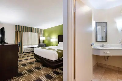 a hotel room with a bed and a sink at Quality Inn Oneonta Cooperstown Area in Oneonta