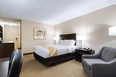 a hotel room with a bed and a chair at Quality Inn Oneonta Cooperstown Area in Oneonta