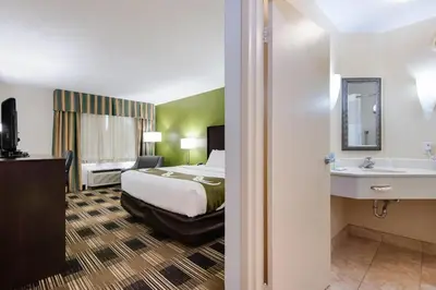 a hotel room with a bed and a sink at Quality Inn Oneonta Cooperstown Area in Oneonta