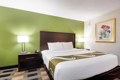 a hotel room with a large bed and two lamps at Quality Inn Oneonta Cooperstown Area in Oneonta