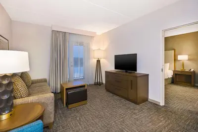 a hotel room with a couch and a flat screen tv at Homewood Suites By Hilton Saratoga Springs in Saratoga Springs