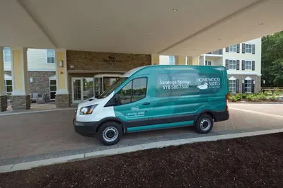 a green van parked in front of a building at Homewood Suites By Hilton Saratoga Springs in Saratoga Springs