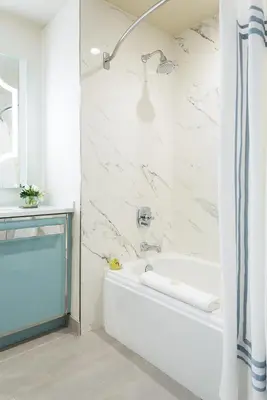 a white bathroom with a tub and a shower at Delamar West Hartford in West Hartford