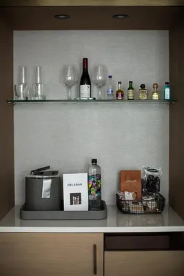 a shelf with wine glasses and a cash register at Delamar West Hartford in West Hartford