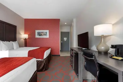 a hotel room with two beds and a desk with a computer at Comfort Inn & Suites near Stadium in Bronx