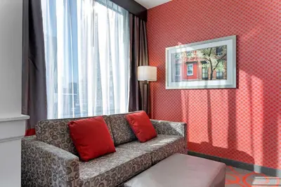 a living room with a couch and a window at Comfort Inn & Suites near Stadium in Bronx
