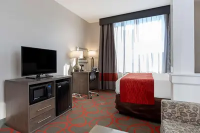 a hotel room with a bed and a flat screen tv at Comfort Inn & Suites near Stadium in Bronx