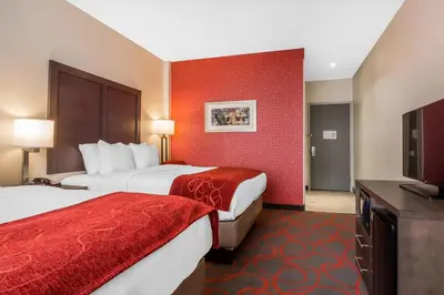 a hotel room with two beds and a flat screen tv at Comfort Inn & Suites near Stadium in Bronx