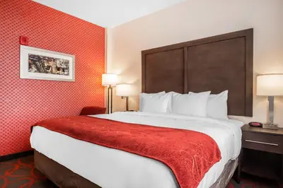 a hotel room with a large bed with a red blanket at Comfort Inn & Suites near Stadium in Bronx
