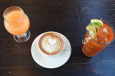 a cup of coffee on a plate next to a drink at Pod Brooklyn in Brooklyn