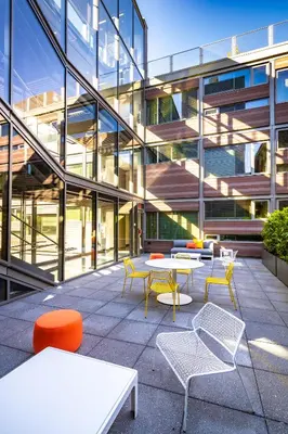 a building with tables and chairs in front of a building at Pod Brooklyn in Brooklyn