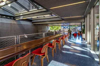 a row of red chairs in a building with a long corridor at Pod Brooklyn in Brooklyn