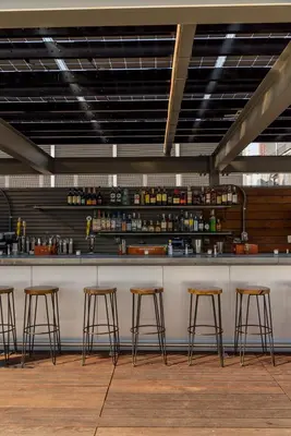 a bar with four stools in front of a counter at Pod Brooklyn in Brooklyn