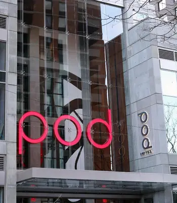 a large glass building with a red sign on it at Pod Times Square in New York