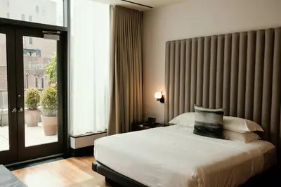 a bedroom with a bed and a large window at Kimpton Hotel Eventi by IHG in New York