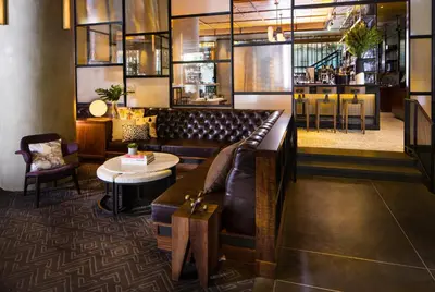a restaurant with a couch and a table and chairs at Kimpton Hotel Eventi by IHG in New York