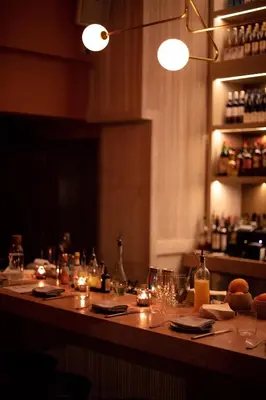 a bar with a table with glasses and lights at Nolitan Hotel SoHo - New York in New York