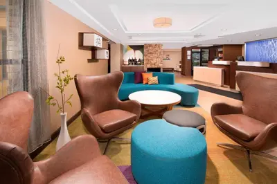 a hotel lobby with a blue couch and chairs at Fairfield Inn & Suites by Marriott Albany East Greenbush in East Greenbush