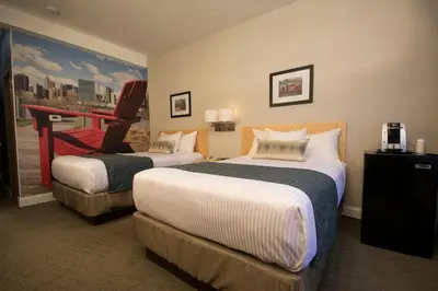 a hotel room with two beds and a chair at Adria Hotel and Conference Center in Queens