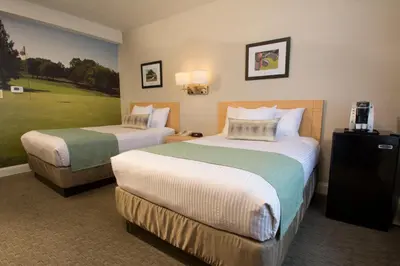 a hotel room with two beds and a golf course at Adria Hotel and Conference Center in Queens