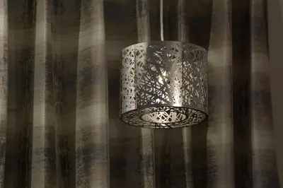 a metal light fixture hanging from a curtain at Adria Hotel and Conference Center in Queens