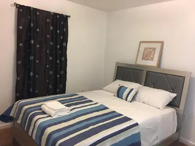 a bedroom with a bed with a striped blanket at Mojoy Homesuites At Runyon in Newark