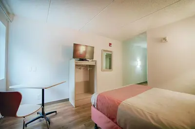 a hotel room with a bed and a desk and a tv at Motel 6-Albany, NY in Albany