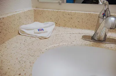 a bathroom sink with a white towel on a counter at Motel 6-Albany, NY in Albany