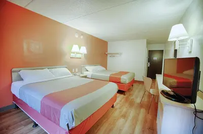 a hotel room with two beds and a flat screen tv at Motel 6-Albany, NY in Albany