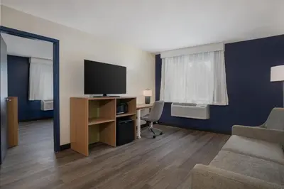 a room with a tv and a chair and a mirror at Spark by Hilton West Coxsackie in West Coxsackie