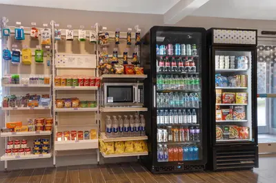 a grocery store aisle with a refrigerator and drinks at Spark by Hilton West Coxsackie in West Coxsackie